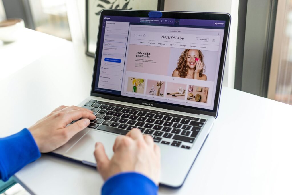 Hands typing on a laptop with an e-commerce website open, showcasing online shopping.